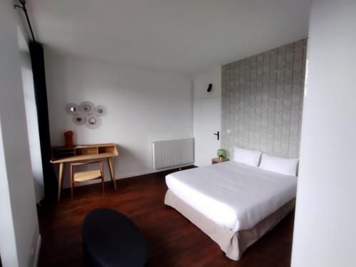 sypialnia z białym łóżkiem i stołem w obiekcie Smart Inn Melun Centre- Appartement 2 chambres w mieście Melun