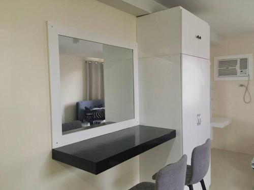 ein Zimmer mit einem Spiegel und 2 Stühlen in einem Zimmer in der Unterkunft Condo , WIFI up to 100mbps , Infinity Pool in Carreta