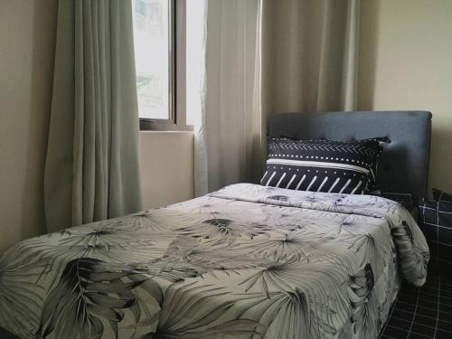 ein Bett in einem Schlafzimmer mit einem Fenster in der Unterkunft Condo , WIFI up to 100mbps , Infinity Pool in Carreta
