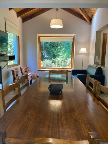 comedor con mesa de madera y sillas en Altos del Sur Cabañas de Montaña en El Bolsón