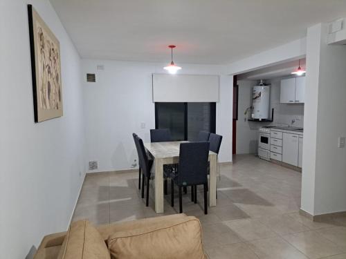 uma cozinha e sala de jantar com mesa e cadeiras em MODERNO DUPLEX Con COCHERA em Luzuriaga