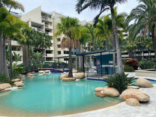 uma grande piscina com uma ponte e palmeiras em City/Valley Resort Apartment em Brisbane