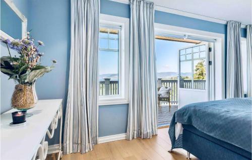 ein blaues Schlafzimmer mit einem Bett und einem Balkon in der Unterkunft Cozy Home In Lier With House A Panoramic View in Lier