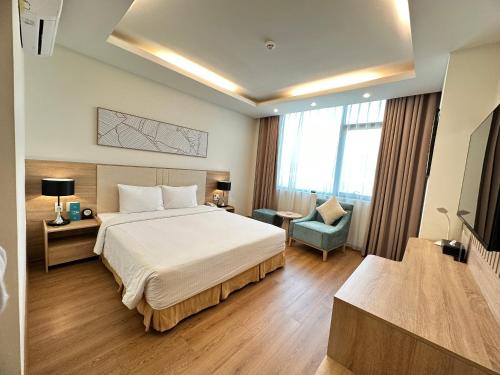 a hotel room with a bed and a chair at Muong Thanh Holiday Vung Tau Hotel in Vung Tau
