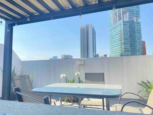 a blue table and chairs on a balcony with buildings at Downtown Depto con Terraza Privada in Mexico City
