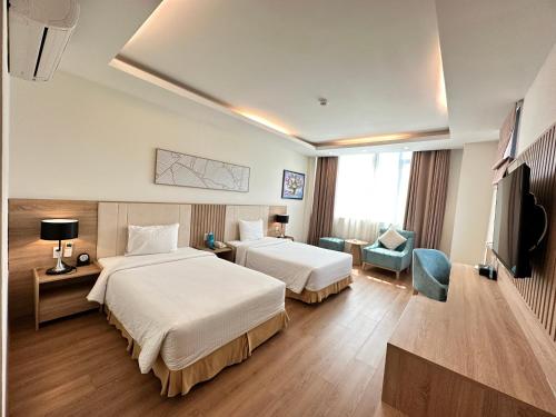 een hotelkamer met 2 bedden en een televisie bij Muong Thanh Vung Tau Hotel in Vung Tau