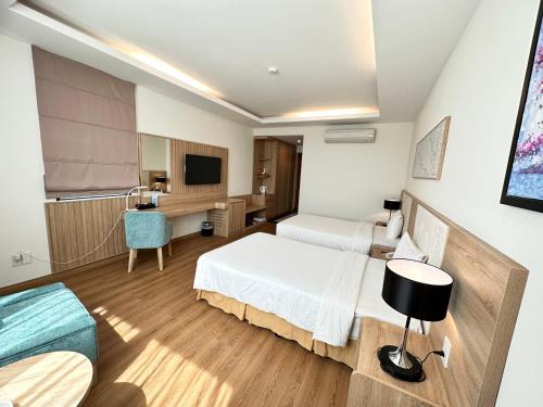 a hotel room with two beds and a television at Muong Thanh Holiday Vung Tau Hotel in Vung Tau