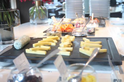 a tray of cheese and other food on a table at Chatrium Grand Bangkok in Bangkok