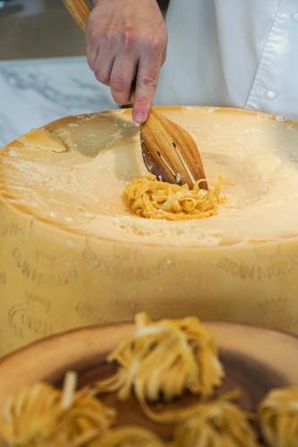 a person using a wooden spoon to eat spaghetti at Chatrium Grand Bangkok in Bangkok