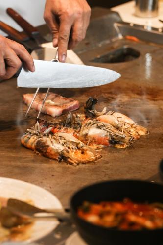 a person preparing food on a table with a knife at Chatrium Grand Bangkok in Bangkok