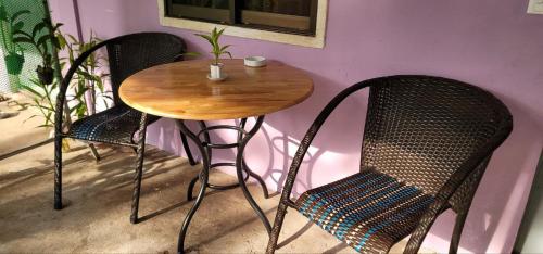 a wooden table and two chairs and a table and chairs at The Purple House in Siem Reap