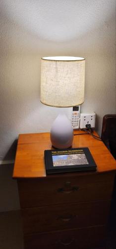 a lamp sitting on top of a wooden table with a lamp gmaxwell gmaxwell gmaxwell at The Purple House in Siem Reap
