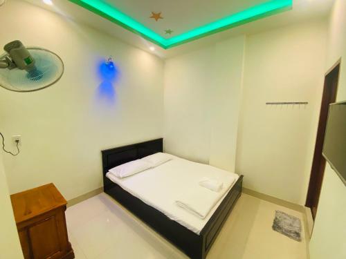 a small room with a bed and a green light at Aloha Hotel in Phan Rang