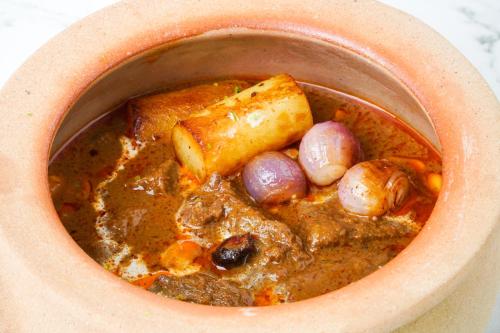a bowl of stew with meat and vegetables in it at Chatrium Grand Bangkok in Bangkok