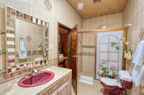 ein Badezimmer mit Waschbecken, Toilette und Spiegel in der Unterkunft La Mexicana Hotel Boutique in San Miguel de Allende