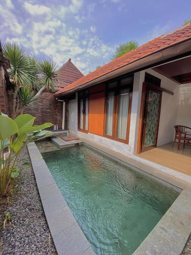 uma piscina em frente a uma casa em chrome hotel & resort solo em Tjolomadu