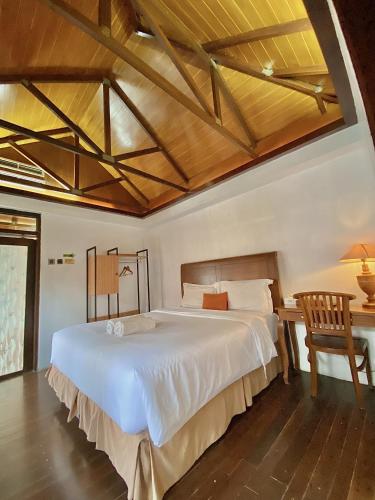 a bedroom with a large white bed and a desk at chrome hotel & resort solo in Tjolomadu