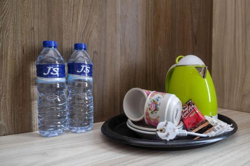 two bottles of water sitting on a table with a plate at Sans Hotel Lynt Makassar in Makassar