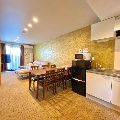 Il comprend une cuisine, un salon et une salle à manger avec une table. dans l'établissement Guest House One More Heart at Kyoto Station South 5, à Kyoto