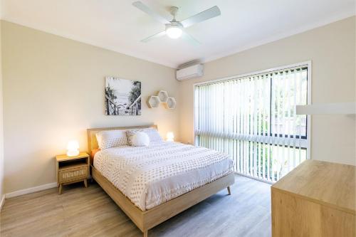een slaapkamer met een bed en een groot raam bij Galoola Hidden Gem, 2 97 Galoola Drive, Pet friendly, Rooftop outdoor area with spectacular views, Wi-Fi and air conditioning in Nelson Bay