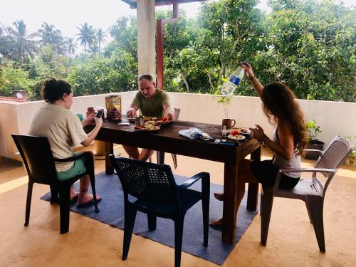 um grupo de pessoas sentadas à volta de uma mesa em Airport Layover B&B em Katunayaka