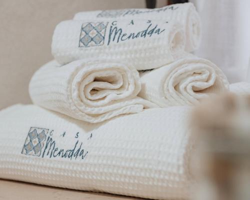 una pila de toallas blancas sentadas en una mesa en Casa Menodda, en Grottaglie