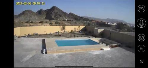a swimming pool on the roof of a house at Al Ghadeer Maison Masfout in Sharīyah