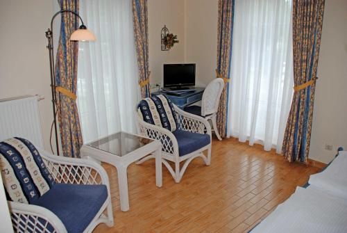 a living room with chairs and a desk with a computer at DEB 021 Hotel in Juliusruh auf Rue in Juliusruh