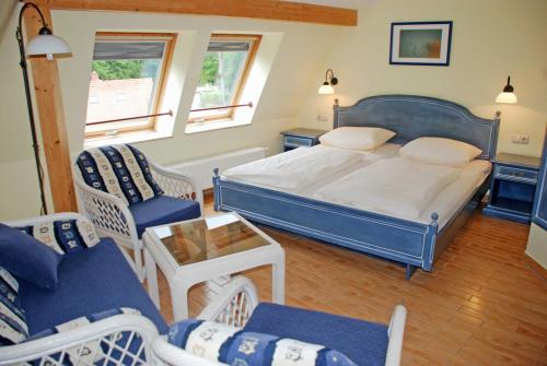 a bedroom with a bed and chairs and a table at DEB 021 Hotel in Juliusruh auf Rue in Juliusruh