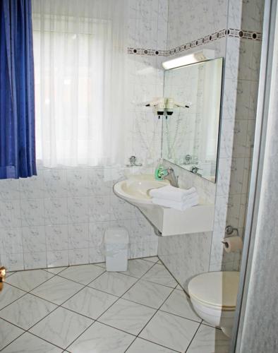 a white bathroom with a sink and a toilet at DEB 021 Hotel in Juliusruh auf Rue in Juliusruh