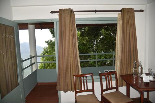 a dining room with a table and chairs and a window at Blackberry Hills Munnar Nature Resort & Spa in Munnar