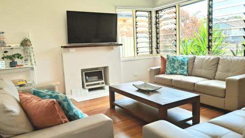 Una sala de estar con dos sofás y una chimenea. en 9 Breckenridge Street, en Forster