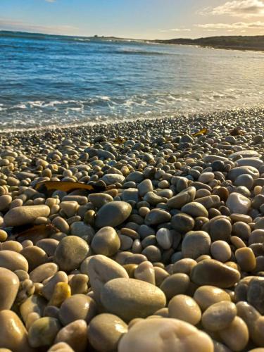 a large group of rocks on a beach near the water at Struispaleis in Struisbaai