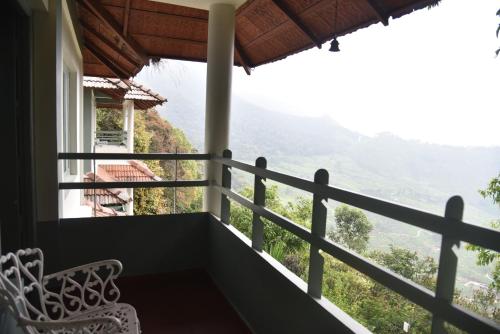 a room with a balcony with a view at Blackberry Hills Munnar Nature Resort & Spa in Munnar