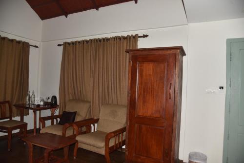 a living room with a table and chairs and a wooden door at Blackberry Hills Munnar Nature Resort & Spa in Munnar