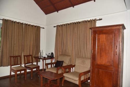 a living room with a table and chairs at Blackberry Hills Munnar Nature Resort & Spa in Munnar