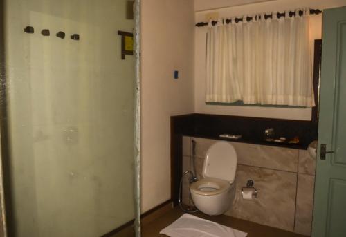 a bathroom with a white toilet and a shower at Blackberry Hills Munnar Nature Resort & Spa in Munnar