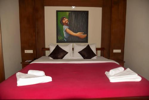 a bedroom with a red bed with towels on it at Blackberry Hills Munnar Nature Resort & Spa in Munnar