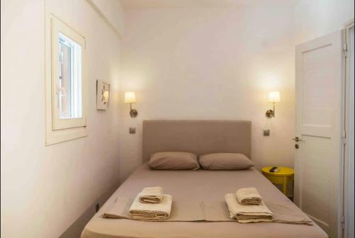 a small bedroom with a bed with towels on it at Private Town Apartments by Mykonos Eight in Mýkonos City