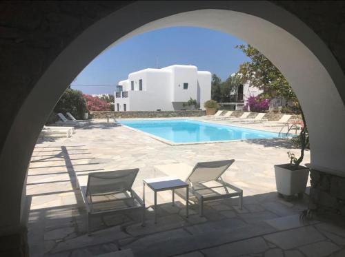 une arche avec des chaises et une piscine dans l'établissement Private Town Apartments by Mykonos Eight, à Mykonos