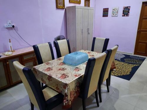 uma mesa e cadeiras com uma mesa e um saco azul sobre ela em MUAZDIANA HOMESTAY di KUALA NERUS, GONG BADAK em Kampong Tanjong Gelam