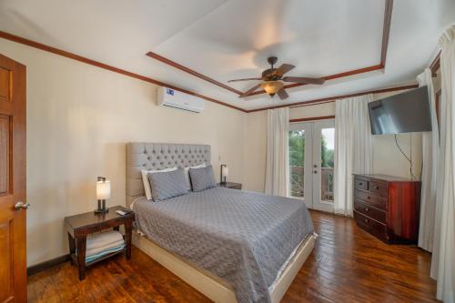 Schlafzimmer mit einem Bett und einem Deckenventilator in der Unterkunft Exclusive Full House - 3 BDRM & 3 BATH - 3min Beach in Roatán