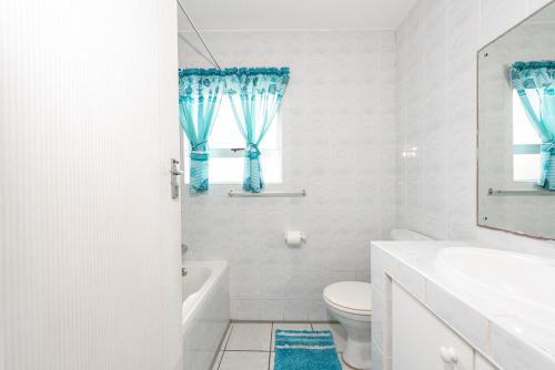 La salle de bains blanche est pourvue de toilettes et d'un lavabo. dans l'établissement LA CRETE SANDS NO 6, à Margate