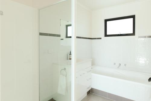 een witte badkamer met een bad en een douche bij Rivers Edge Retreat in Orford