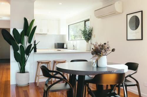 a kitchen and dining room with a table and chairs at Rivers Edge Retreat in Orford
