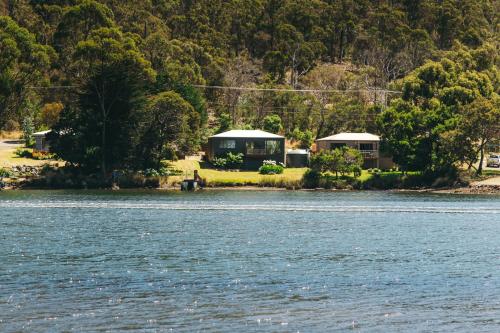 a house on the shore of a body of water at Rivers Edge Retreat in Orford