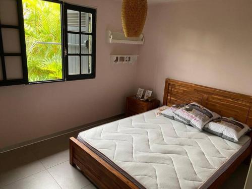 a large bed in a bedroom with a window at Villa avec piscine au centre de la rivière in Saint-Louis