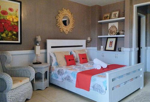ein Schlafzimmer mit einem Bett, einem Stuhl und einem Spiegel in der Unterkunft RedDoorz @ Vine Molave in Molave