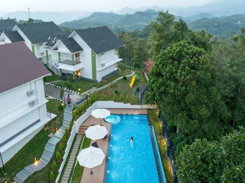 an aerial view of a resort pool with umbrellas at Sprise Munnar Resort and Spa in Munnar