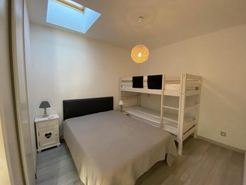 a small bedroom with a bed and a shelf at Maison Capbreton, 3 pièces, 6 personnes - FR-1-413-115 in Capbreton